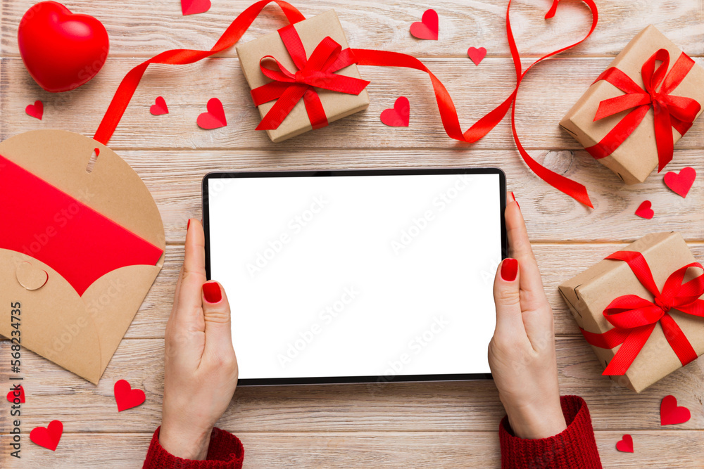 Female hands using a laptop for Valentine day background, gift box and envelope, hearts Female hands using a laptop for Valentine day background, gift box and envelope, hearts