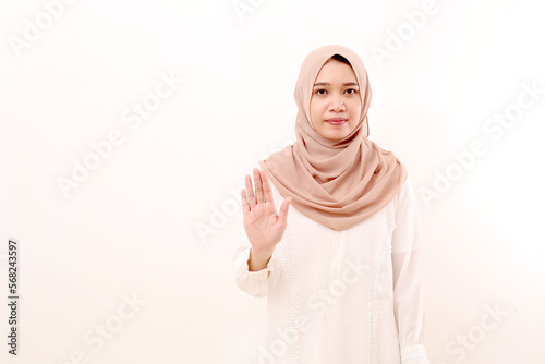 Canvas Print Young asian muslim woman standing while showing stop hand gesture