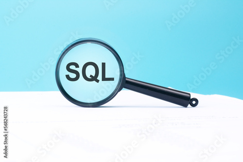 look at the text SQL through a magnifying glass on a blue and white background