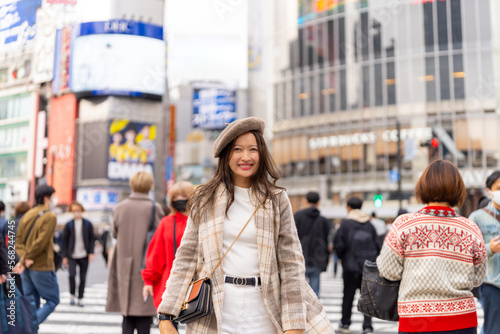 Photography Happy Asian woman shopping and crossing street crosswalk with crowd of people at Shibuya, Tokyo, Japan in autumn
