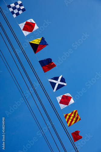 Nautical flags against blue sky.
