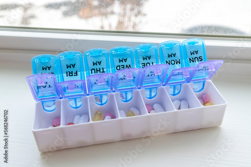 A full pill box or vitamin organizer with the days of the week separated individually by am and pm to help remind when medication should be taken. photo