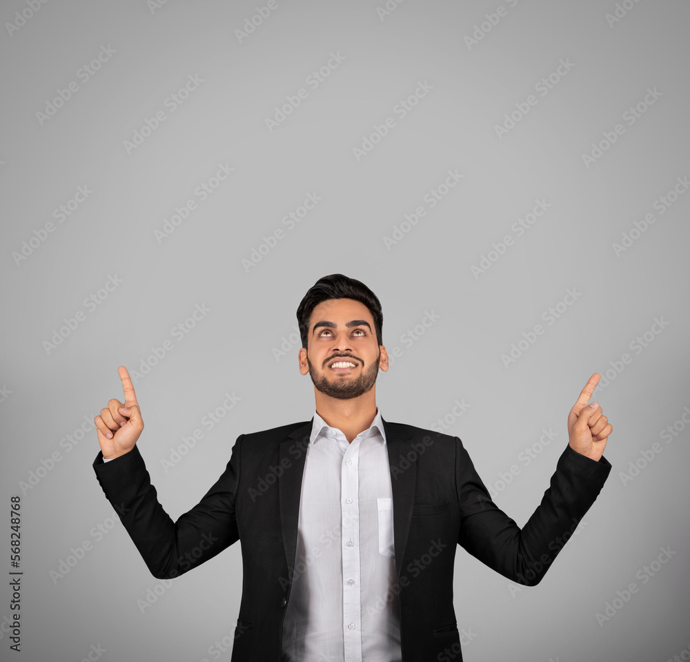 Check This. Smiling Young Arab Businessman Pointing Up At Copy Space Check This. Smiling Young Arab Businessman Pointing Up At Copy Space