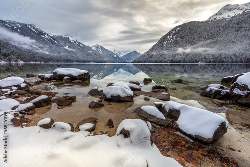 Winter landscape at Chilliwack Lake with snowy shoreline and mountains reflected in clear water