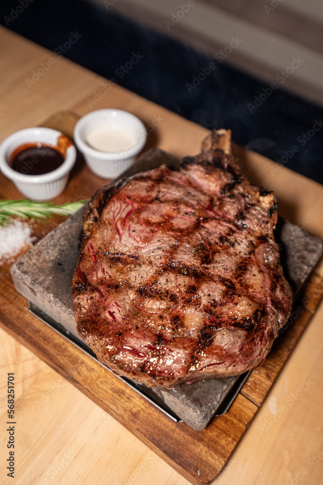 Ribeye steak with bone in on wooden board