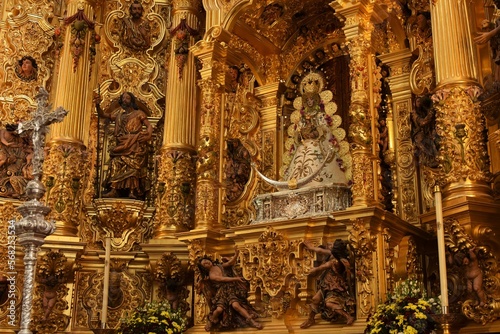 Finely dressed 17th century sculpture of the Virgin of El Rocío with Child in crowned ruling pose on a crescent symbolizing immaculate conception and victory at Lepanto, El Rocío, Spain photo