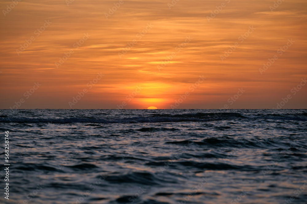 Ocean sunset. Big white sun on dramatic bright sky background, soft evening horizont over sea dark water