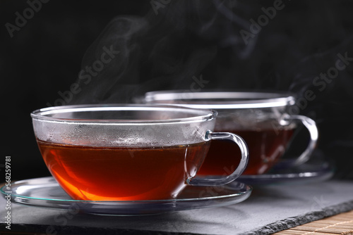 Aromatic hot tea in glass cups on table, closeup