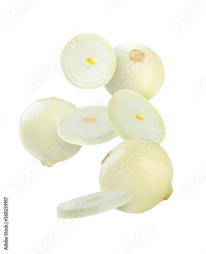 Whole and cut onion bulbs falling on white background