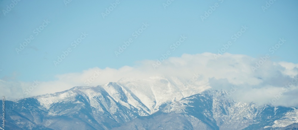 Snow-capped mountains with blue sky and space for text. Winter background.