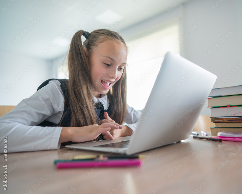 Caucasian girl studying on a laptop in a classroom. Caucasian girl studying on a laptop in a classroom.