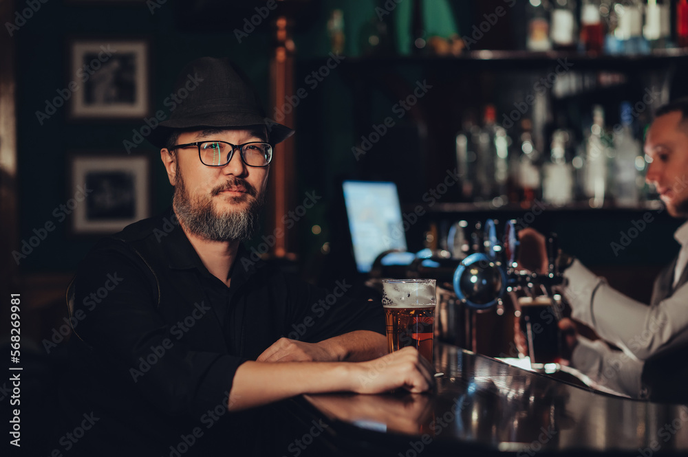 man with a glass of beer at bar counter in a pub