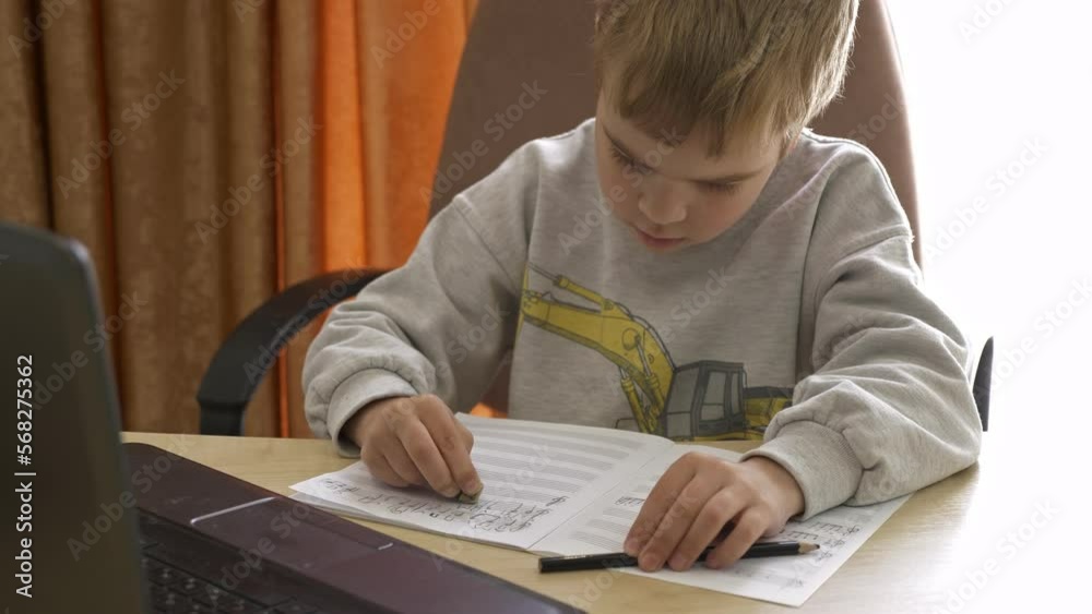 Kid Erases Mistakes with Rubber Eraser. Little Boy Distance Remote Study Music Online on Laptop at Home Sitting at Desk. Slow motion 4K Kid Erases Mistakes with Rubber Eraser. Little Boy Distance Remote Study Music Online on Laptop at Home Sitting at Desk. Slow motion 4K