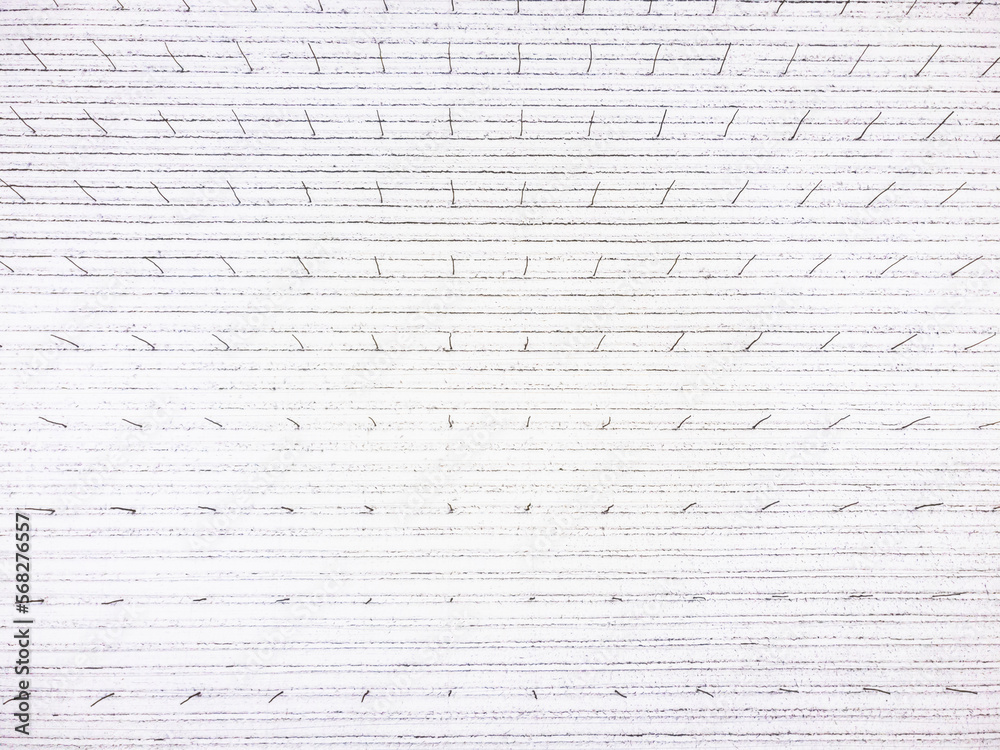 Top down drone view of empty hop field covered in snow