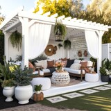 a boho and cozy backyard entertaining area under a white wooden pergola on concrete with touches of rattan, AI assisted finalized in Photoshop by me