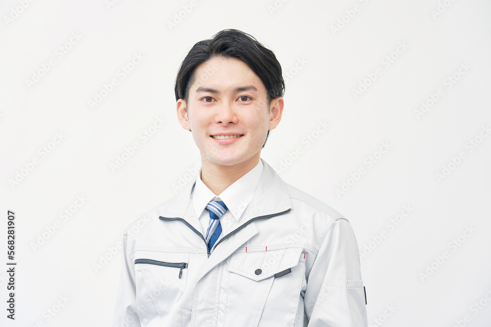 カメラ目線の作業着の男性のポートレート　白背景