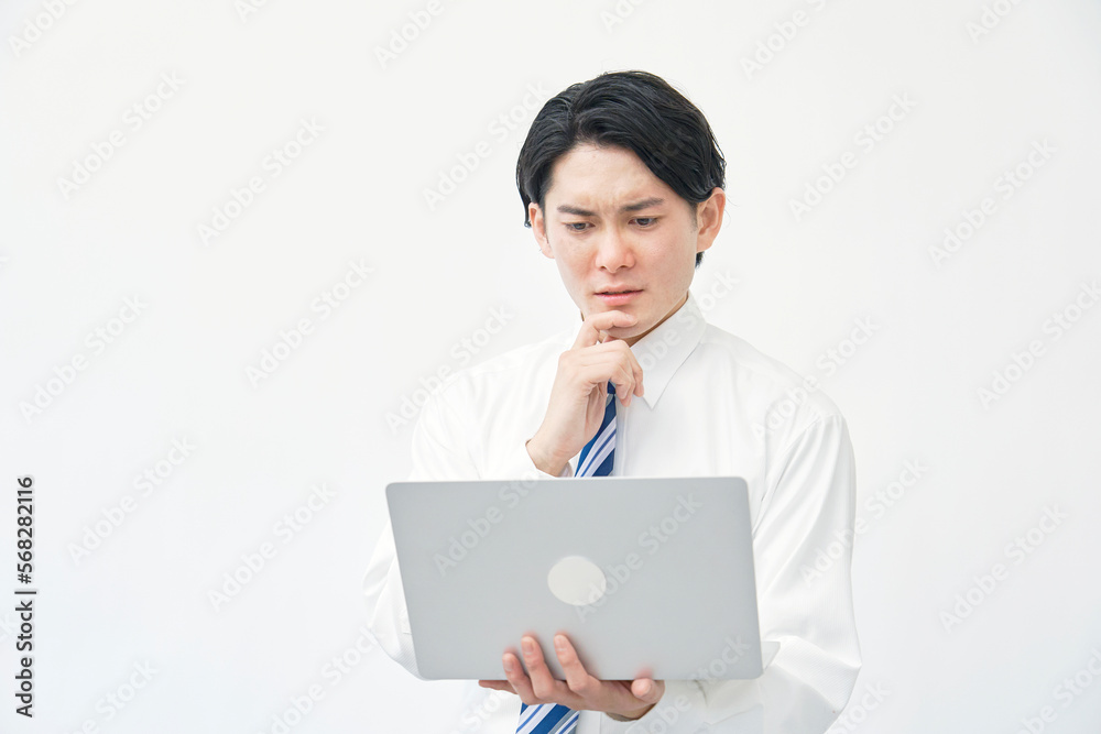 パソコンを持って悩むビジネスマン　白背景
