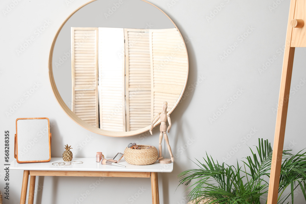 Table with mirror, brushes, cosmetics and wooden mannequin in makeup room Table with mirror, brushes, cosmetics and wooden mannequin in makeup room