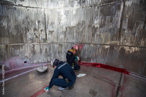 Male into work inspection process chemical color paint  weld red stainless steel tanks the area confined space