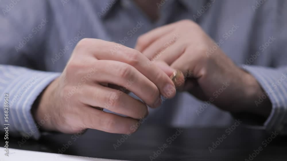 Divorce. The end of the relationship. The man takes off his wedding ring and signs the divorce documents at the lawyer's office. Divorce. The end of the relationship. The man takes off his wedding ring and signs the divorce documents at the lawyer's office.