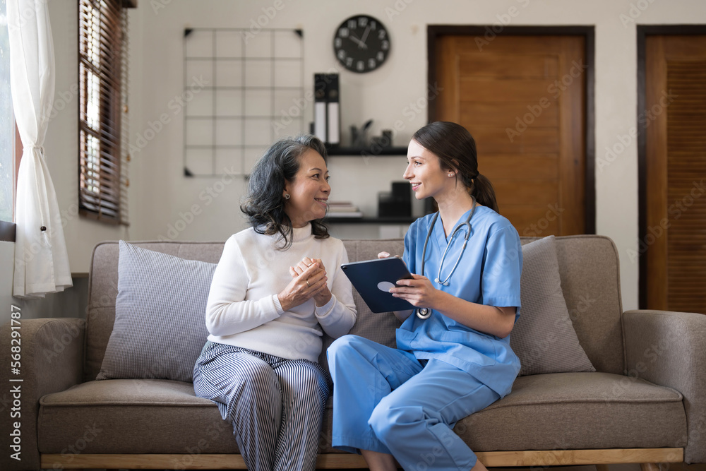Asian nurse showing health checkup report to grandmather and giving advice. medical assisted living visit senior patient at home. Home nursing and healthcare caregiver concept Asian nurse showing health checkup report to grandmather and giving advice. medical assisted living visit senior patient at home. Home nursing and healthcare caregiver concept