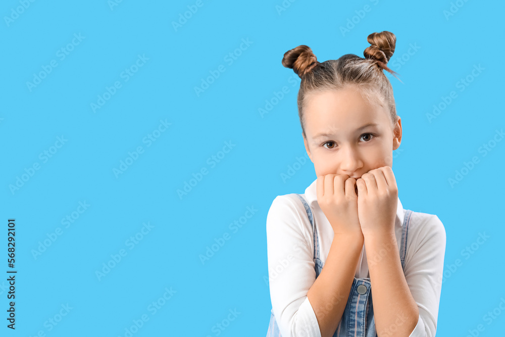 Little girl biting nails on blue background, closeup Little girl biting nails on blue background, closeup