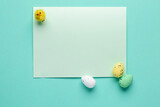 Blank card, toy chick and Easter eggs on color background