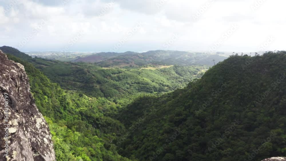 Picturesque flying over the mountain creek fall down from steep high cliff to wide valley. Cascade 500 Pieds waterfall on Mauricius island in Indian ocean. Picturesque flying over the mountain creek fall down from steep high cliff to wide valley. Cascade 500 Pieds waterfall on Mauricius island in Indian ocean.