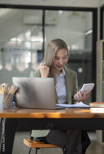 Cheerful asian businesswoman working at table office. 