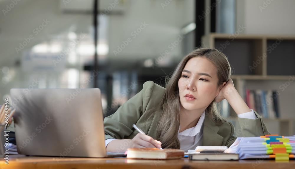 Asian businesswoman are stressed and tired from work sitting at desk in the office, feeling sick at work, stress from work. Asian businesswoman are stressed and tired from work sitting at desk in the office, feeling sick at work, stress from work.