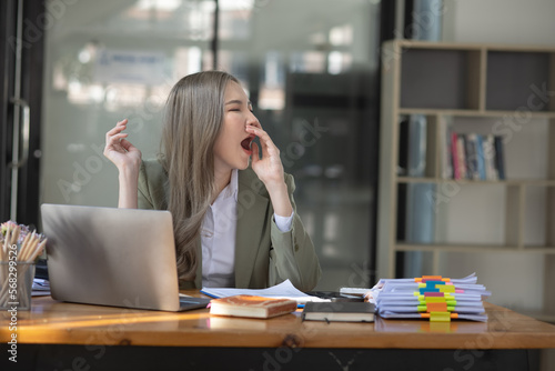 Asian businesswoman are stressed and tired from work sitting at desk in the office, feeling sick at work, stress from work. 