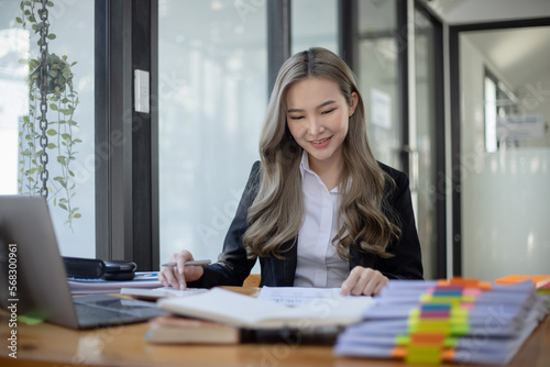 Cheerful asian businesswoman working at table office. 