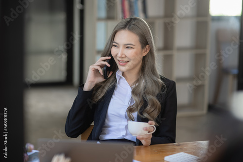 Cheerful asian businesswoman working at table office. 
