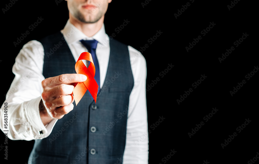 Hiv aids. Red ribbon in hiv world day isolated on dark background. Man ...