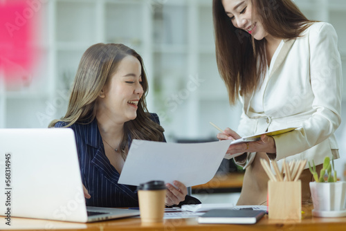 Asian business woman working with paper note on glass wall, Business people meeting to share idea at office, Business planning and Sticky note on glass wall.