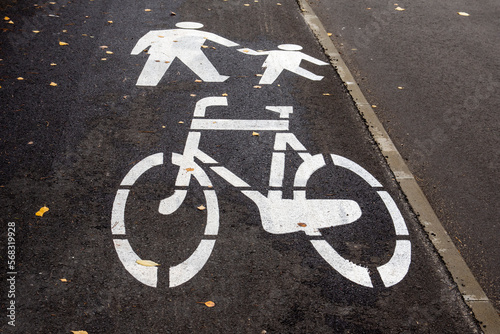 Horizontal white warning signs for bicycles, pedestrians and vehicles. Asphalt.