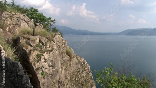 Roof gazebo in Chinese style on coast of Fuxian Lake in Yunnan Province China. Unique mountain lake in East Asia. Landscape on background of sky with gray clouds and fog. photo