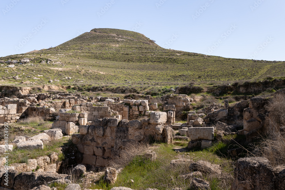 The ruins  of the outer part of the palace of King Herod, against the background of the filled artificial hill in which they are located the palace of King Herod - Herodion, in Israel