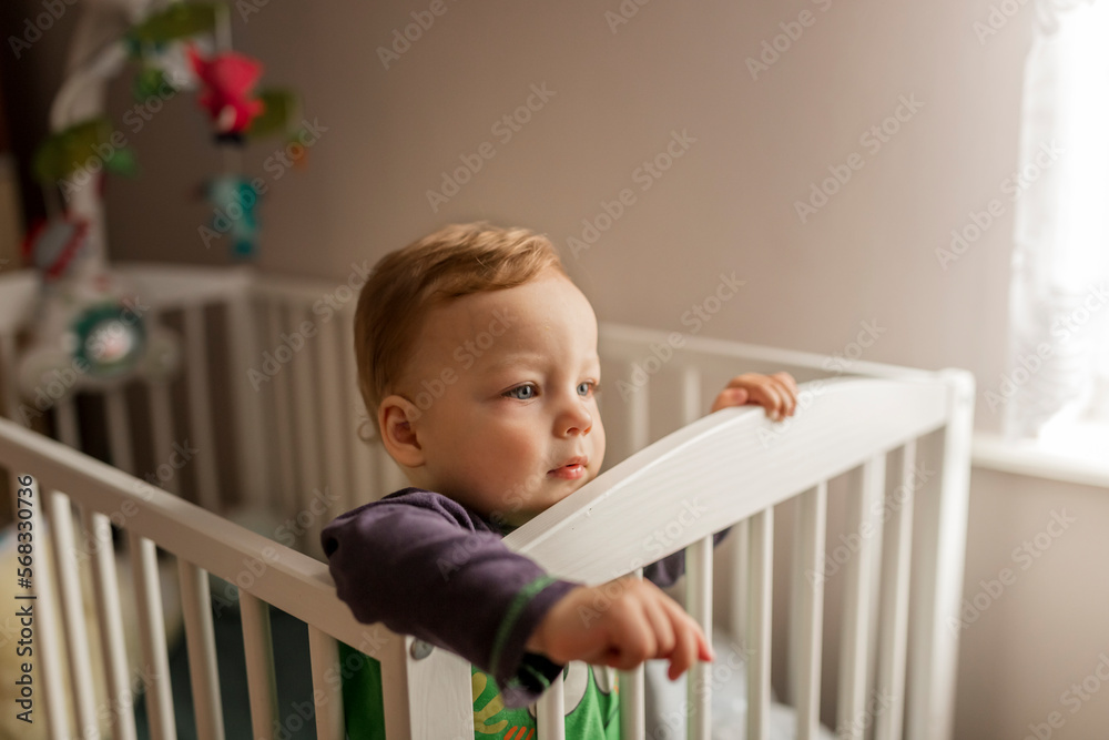 Small blonde boy standing in his crib Small blonde boy standing in his crib