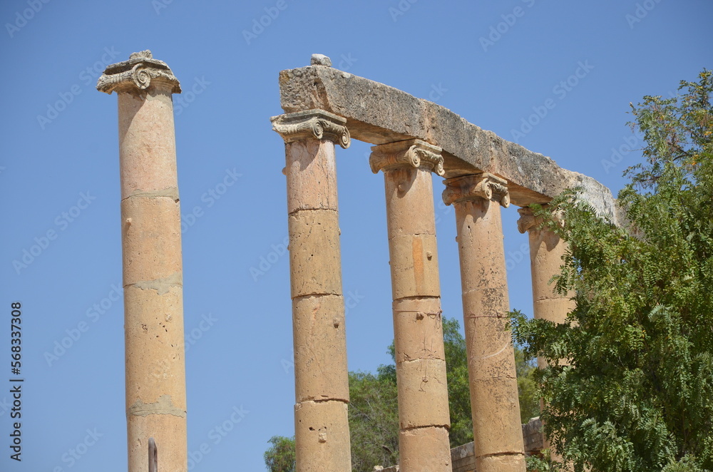 Sunny temples, arches, the Nymphaeum, stone ornaments, columns and column bases on the ruins of the city of Jerash in Jordan. Sunny temples, arches, the Nymphaeum, stone ornaments, columns and column bases on the ruins of the city of Jerash in Jordan.
