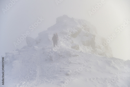 Climbing tourists in winter to the peak of a mountain peak © gluk_nfl