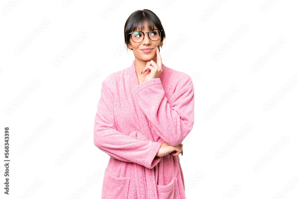Young woman in bathrobe over isolated chroma key background thinking an idea while looking up