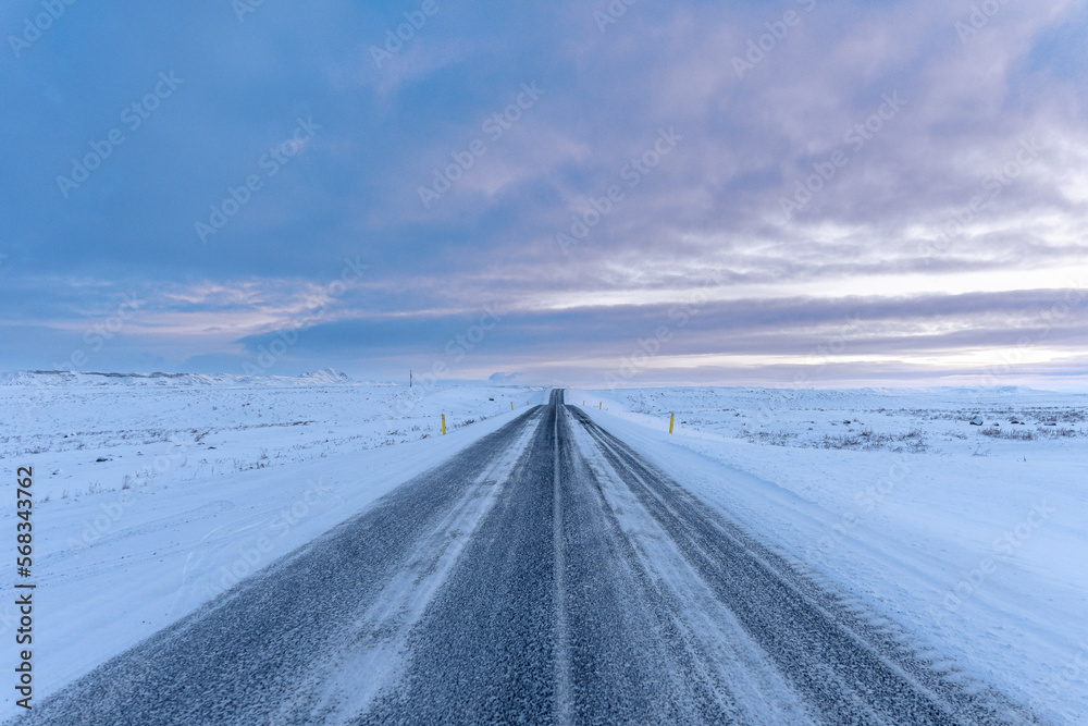 Iceland winter panorama road snow landscape with cloudy light pink violet sky sunset Iceland winter panorama road snow landscape with cloudy light pink violet sky sunset