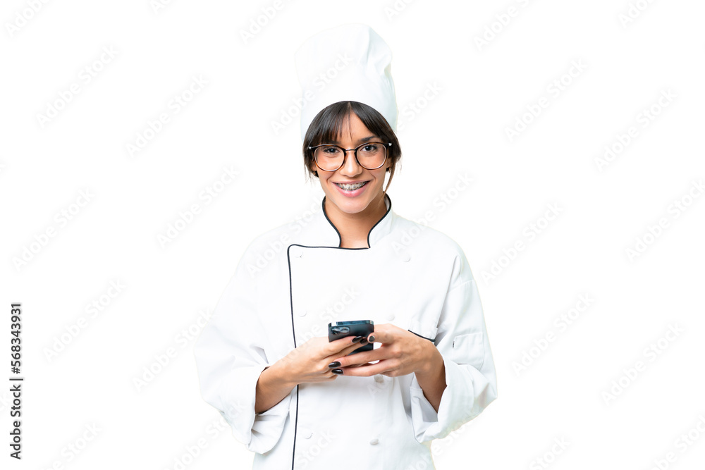 Young caucasian chef woman over isolated chroma key background sending a message with the mobile Young caucasian chef woman over isolated chroma key background sending a message with the mobile