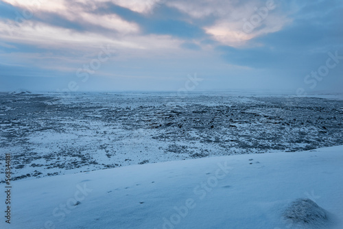 Iceland snow covered vulcanic area in winter with cloudy blue yellow sky © Simon Schmitt