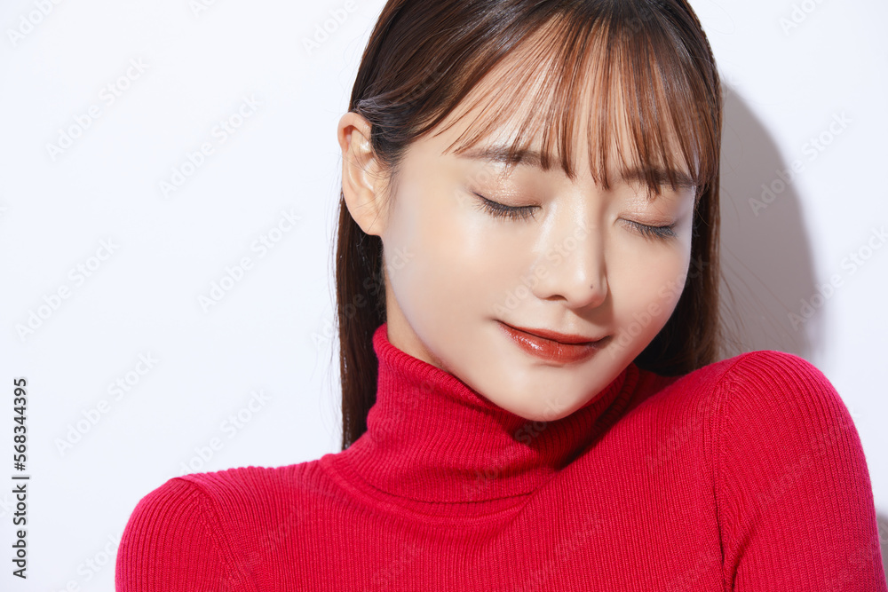 Naklejka premium 赤いニットを着た若い女性のビューティー ポートレート