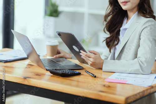 Portrait of young business woman working on laptop, 