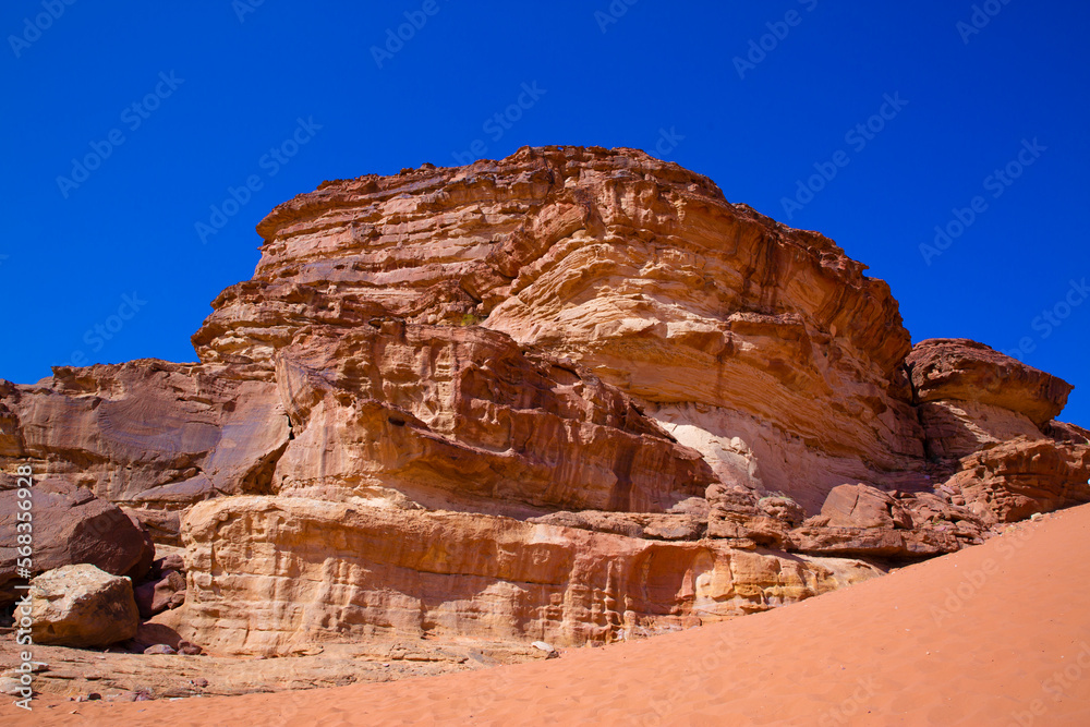 Fototapeta premium Wadi Rum desert in Jordan. Beautiful red pink sand dunes and rocky mountains, beautiful blue summer sky.