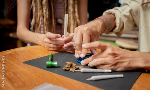 Hippie style couple making medical marijuana cigarettes