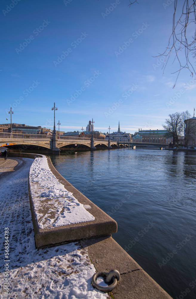 Pier foot path way, the bridge Vasabron and the old town Gamla Stan a sunny snowy winter day in Stockholm